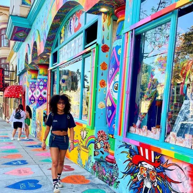 一个女人走在海特街，背景是彩色壁画.