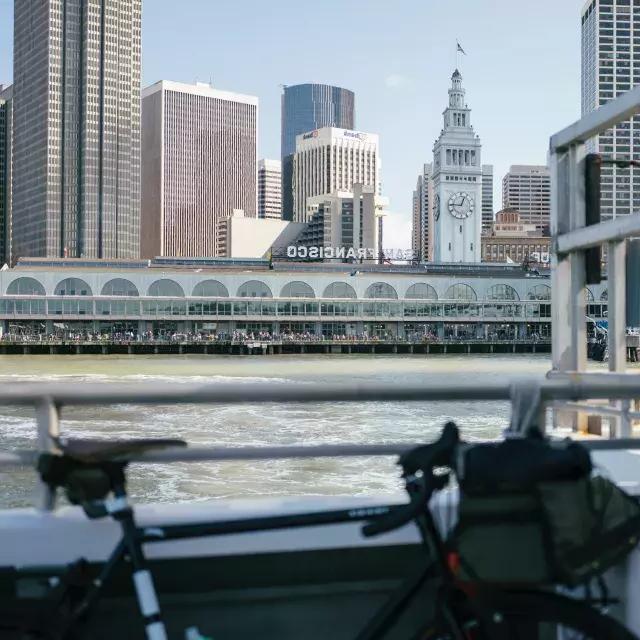 自行车靠在铁轨上，背景是渡轮大厦.